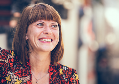 smiling woman with full fringe looking to the right