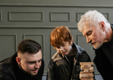 parent and grandparent playing jenga with young boy