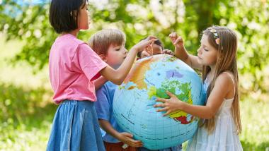 children looking at a globe