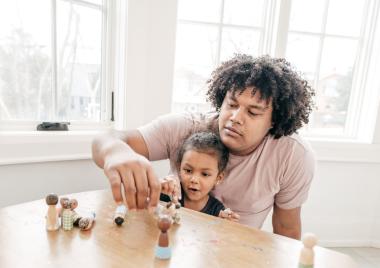 A carer with a young child playing blocks